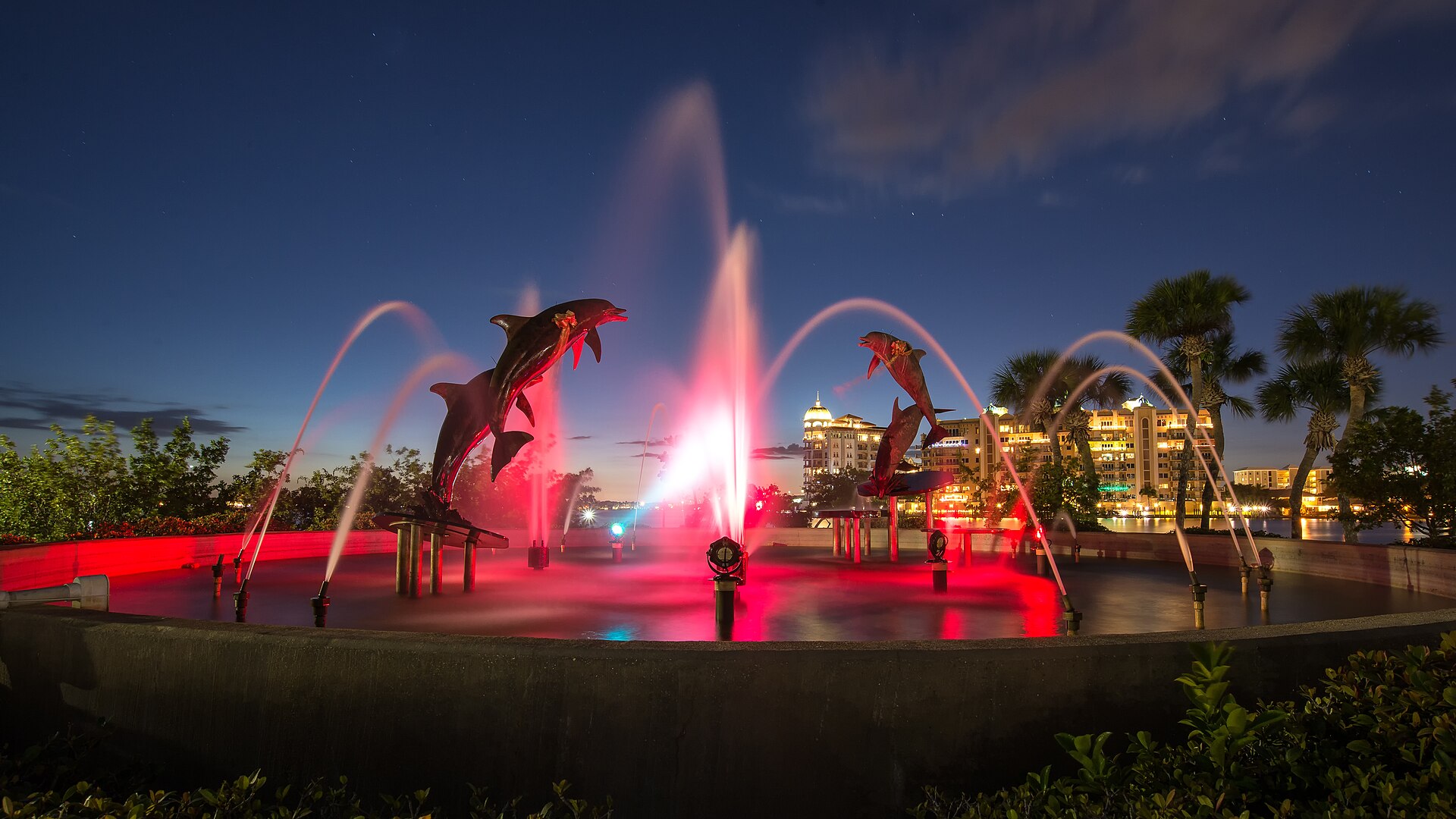The Dolphin Fountain at Island Park on the Sarasota bayfront, lit at night